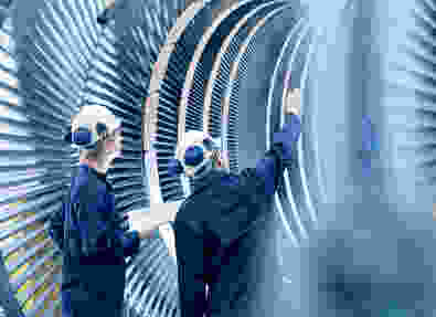 Engineers in front of a power plant turbine